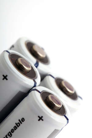 four white rechargeable batteries on white background with copyspaceの写真素材