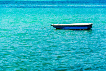 Boat on Blue sea and a moving reflection of sunlightの写真素材