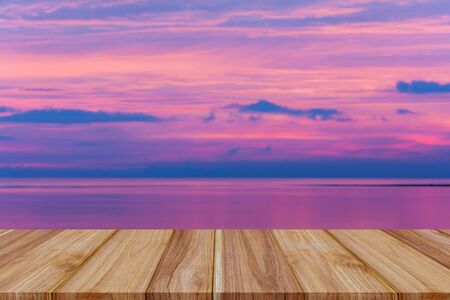 Top wood table view Blue sea and a moving smooth reflection of sunlight . White sandy beach on vacation at sunsetの写真素材