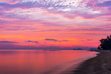 Blue sea and a moving reflection of sunlight . White sandy beach on vacation at sunsetの写真素材