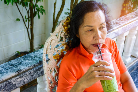 Middle-aged women sit leisurely at home during the dayの写真素材