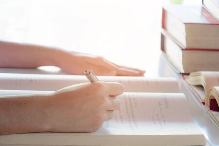 Man writing pen in book on white table at home