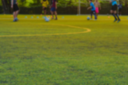 Children play football in the practice field.blurred focusの写真素材