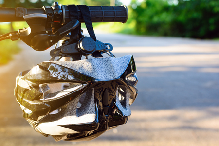 Bike helmet and bike on the street and evening sunの写真素材