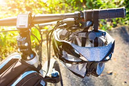 Bike helmet and bike on the street and evening sunの写真素材