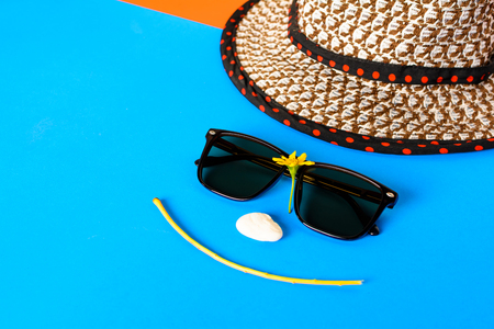 Sunglasses and hats on colorful blue and orange paper with Face smile and relax time. selective focusの写真素材