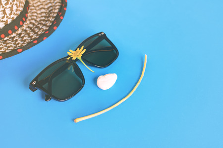 Sunglasses and hats on colorful blue and orange paper with Face smile and relax time.pastel styleの写真素材