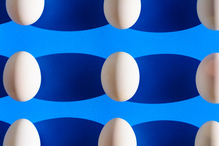 Raw duck eggs white and shiny black on blue paper with minimal and easterの写真素材