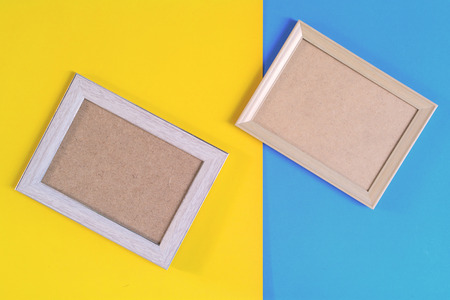 Photo wood frame on colorful paper wall background With memories and nobodyの写真素材