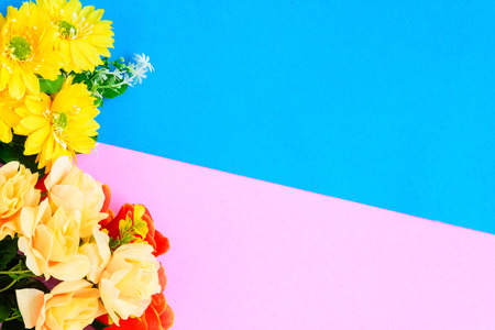 Flat lay fresh flowers on colorful paper with decor and design.の写真素材
