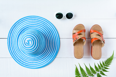 Blue hat sunglasses and shoe on white wood table with travel and fashion styleの写真素材