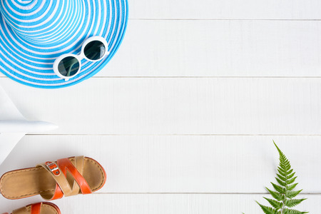 Blue hat sunglasses and shoe on white wood table with travel and fashion styleの写真素材