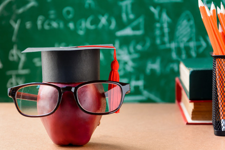 Apple Knowledge Symbol and Pencil Books on the desk with green board backgroundの写真素材