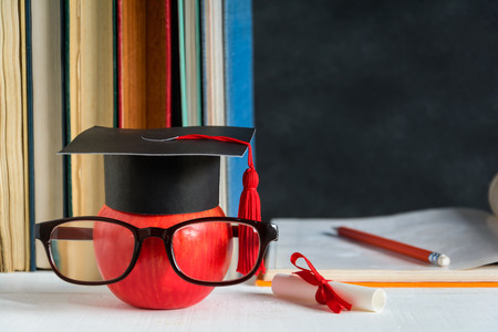 Apple Knowledge Symbol and Pencil Books on the desk with board background.Education concept schoolの写真素材