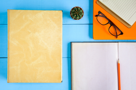 top view book mockup and pencil note on blue wood table with cactus decoration on deskの写真素材
