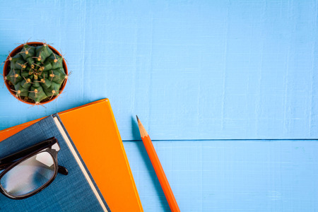 top view book mockup and pencil note on blue wood table with cactus decoration on deskの写真素材