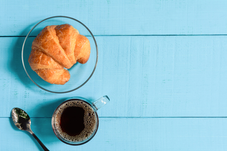 top view good morning black coffee cup and bread on a wooden table in the sunrise background. breakfast and wake upの写真素材