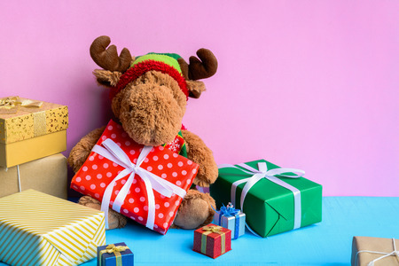 doll and gift boxes on wood desk pink wall background and color pastel with the holiday seasonの写真素材