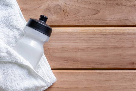 top view white cloth and plastic water bottle on wooden table With exercise to health conceptの写真素材