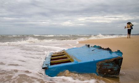 woman in traditional vietnamese hat walking along beachの写真素材