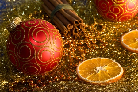 red christmas ball, cinnamon,   orange and beads on gold background の写真素材