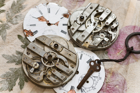 old pocket watch on handmade paper with leavesの写真素材