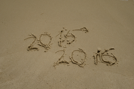 new year numbers 2015 and 2016  drawings in the sand on the beach
