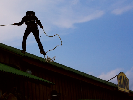 cowboy gets off the roof, holding the ropeの写真素材