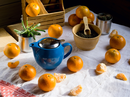 blue teapot with green  tea and mandarin on white rustic tableclothの写真素材