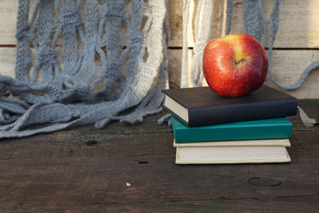 Apple on pile of books at the wooden tableの写真素材