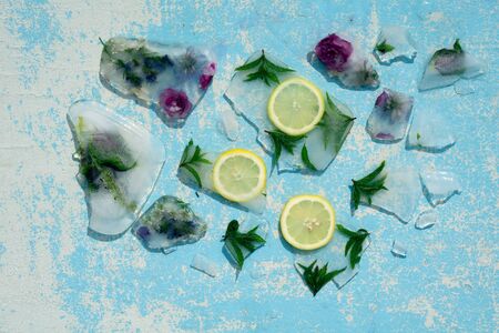 Background    green leaves of  mint  and lemon in ice   cube with air bubblesの写真素材