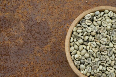 green coffee beans in wooden bowl, close-up.の写真素材