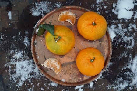 Clementines tangerines on copper tray   as Christmas decor over snow background.  New Year cards and decorations.の写真素材