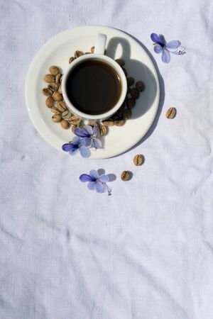 Flat lay Coffee composition  with  white cup  and beans of coffe on  linen tableclothtable as backgroundの写真素材