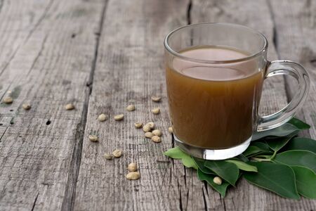 Coffee composition  with  glass  cup    of coffe with herb  and beans of coffe,   on rustic  wooden table  as backgroundの写真素材