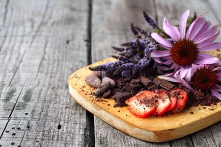  Flat lay  of Raw cocoa beans,  cocoa powder, chocolate on sacking  with mint and flower, strawberry on wooden  as background, top viewの写真素材