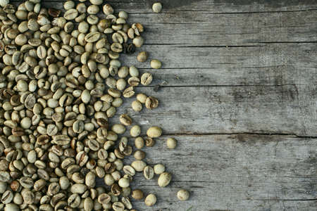 Background of green coffee beans on rustic wooden as backgroundの写真素材