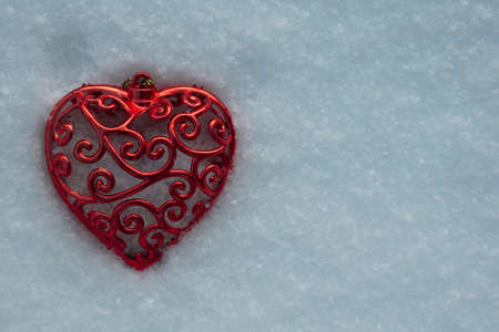 Valentine's Day background with Frozen beautiful red heart in snowの写真素材