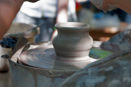 Potter shaping a ceramic pot on a pottery wheel