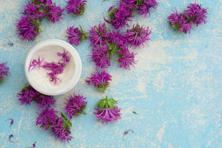Spa and facial beauty herbal cosmetics with flower on blue wooden background. Spring skin care trends. Top view branding concept gift for woman.の写真素材