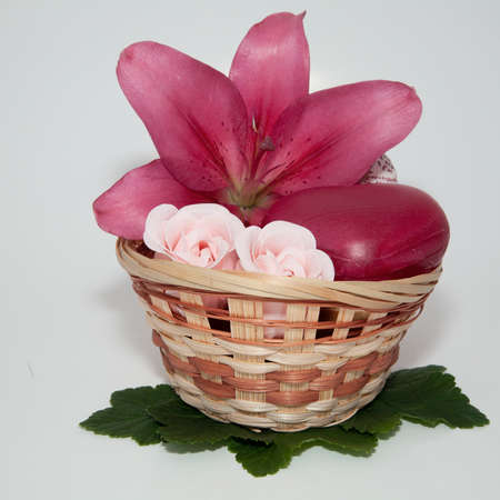 soap with natural ingredients and red lily flowers in basket on white backgroundの写真素材