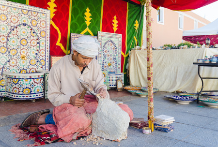 Badajoz, Spain - September 23, 2016: Sculptor arabic man working sculpting sculpture in market during celebration of Almossassa, Badajoz, Extremadura, spainのeditorial素材