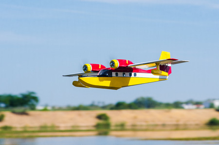 Radio controlled model hydroplane  flying on a nice cloudy day .