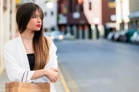 Beautiful young woman waiting in the street with copy space for textの写真素材