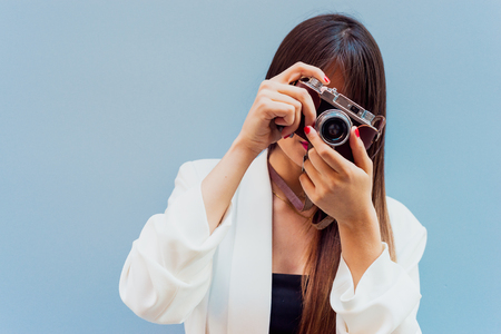 Beautiful young woman using old retro cam with copy space for text.の写真素材