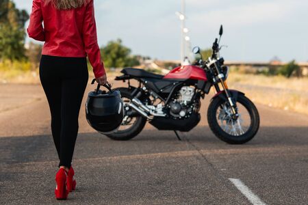 back view of woman going to classical motorbikeの写真素材