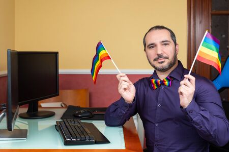 Man with lgbt flags and bow tie teleworkingの写真素材
