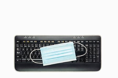 computer keyboard with a medical mask on it. Top view with space for copy