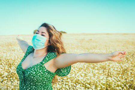 woman with medical mask enjoying freedom in the countryの写真素材