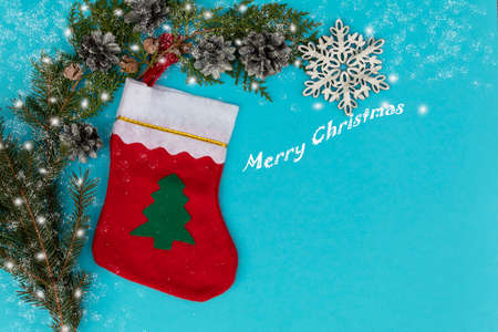 On a blue background lies a Christmas golf course for gifts, branches of conifers, cones and a...